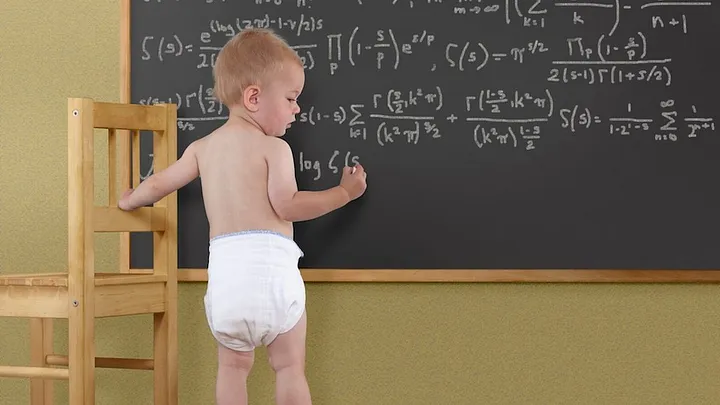 Baby teaching at chalkboard