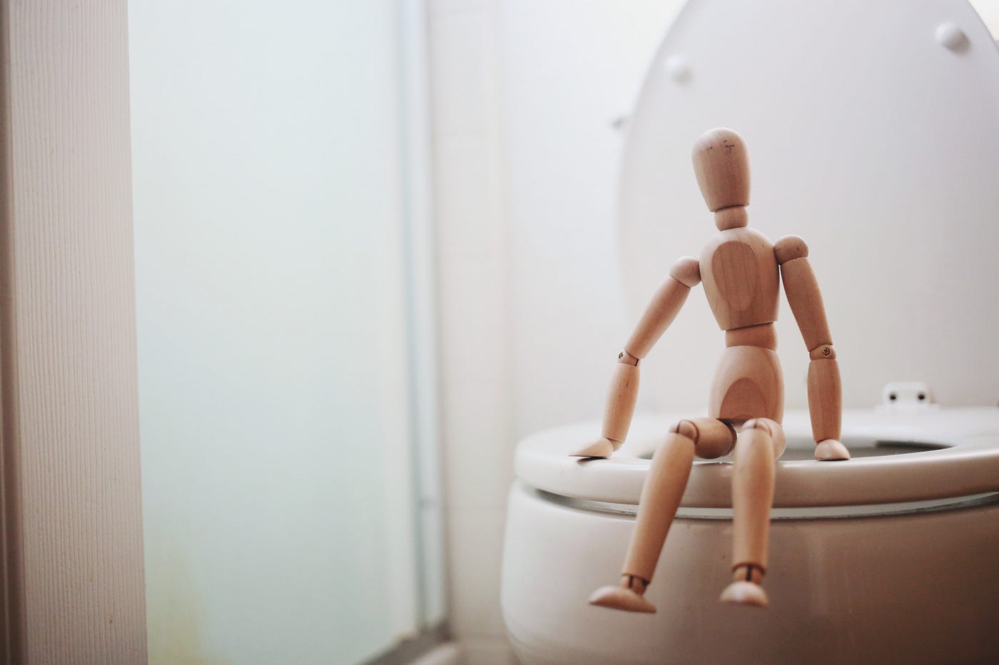 wooden person sitting on toilet